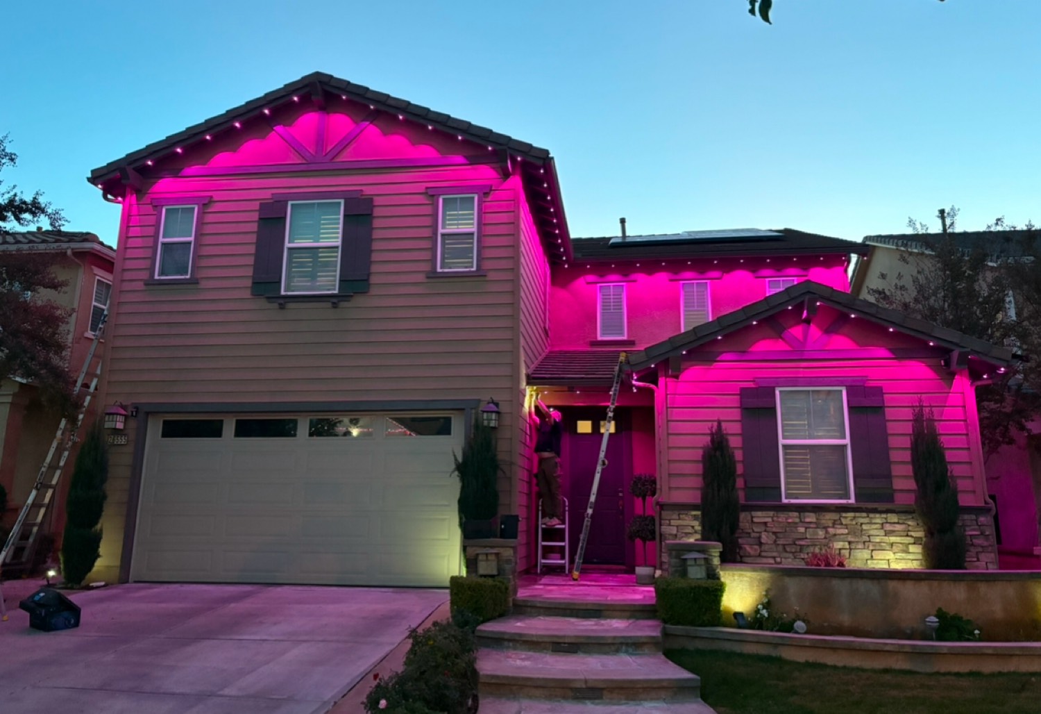 Pink LED lighting at dusk with installer